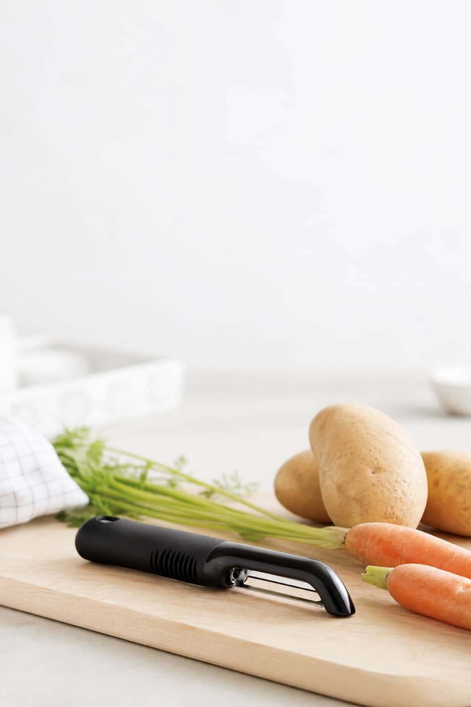 OXO peeler beside potatoes and carrots