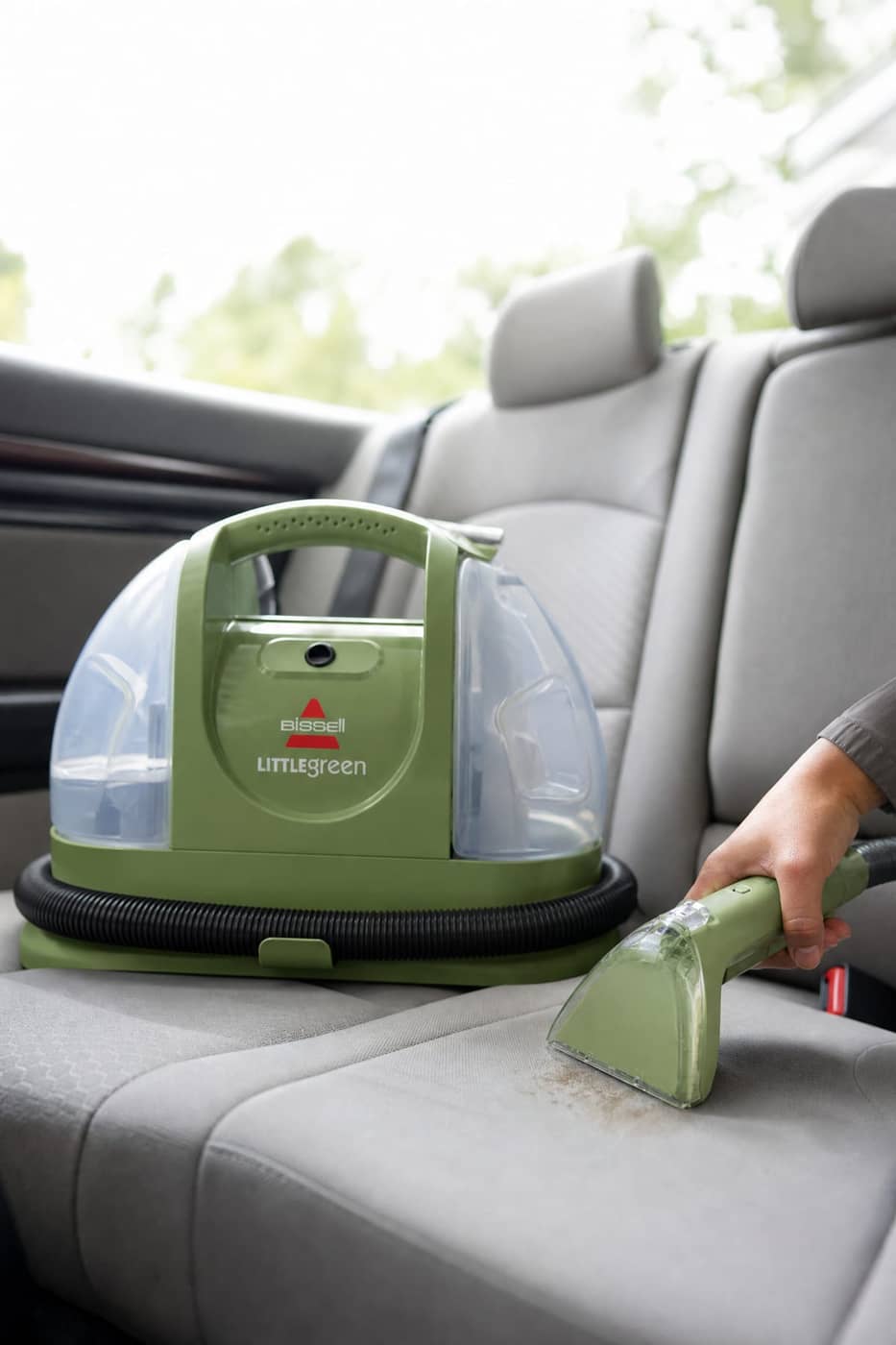 BISSELL Little Green in a car seat cleaning scene