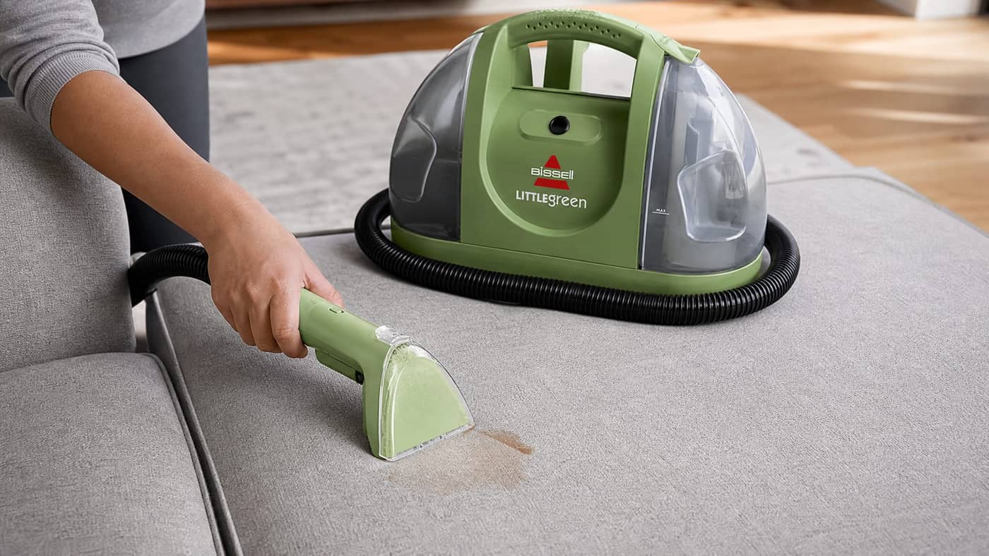 BISSELL Little Green cleaning a sofa cushion